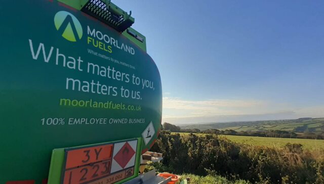 Back view of a green Moorland Fuels delivery truck with a scenic landscape in the background, featuring the slogan 'What matters to you matters to us'