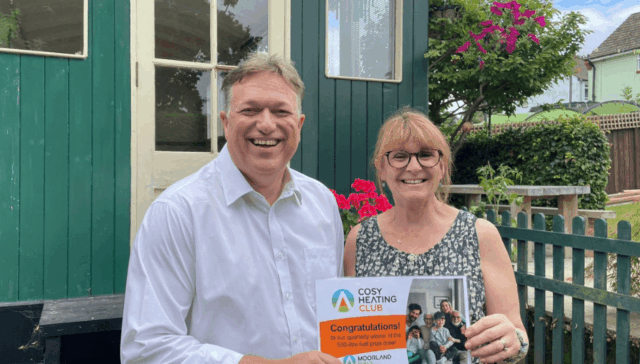Man and Woman smiling with their Cosy Heating Club Winner Certificate
