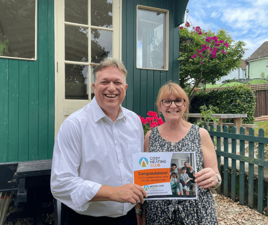 Man and Woman smiling with their Cosy Heating Club Winner Certificate